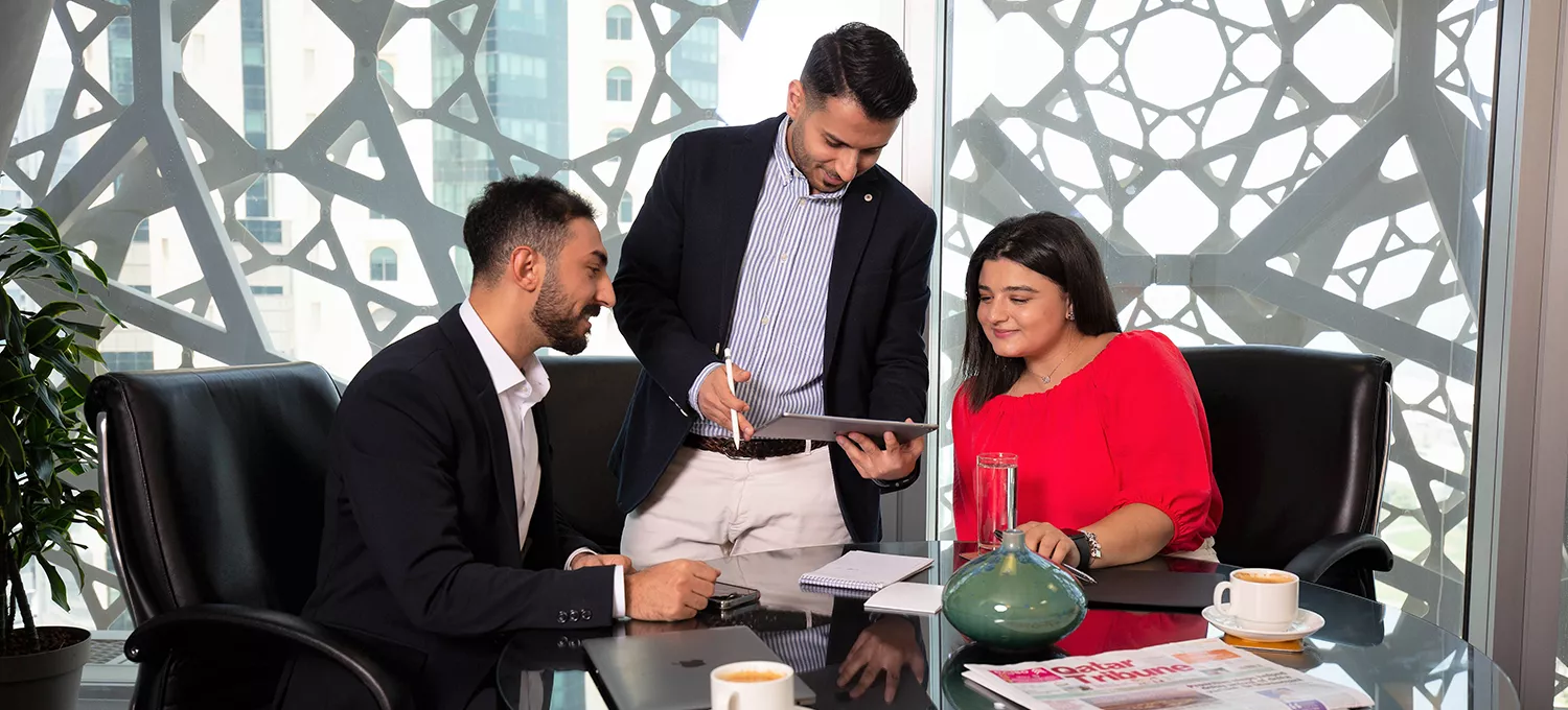 Servcorp team assists clients in a meeting room with skyline views at Doha Tower, West Bay, Doha.