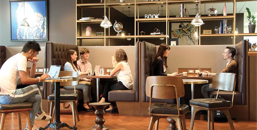 Clients working in a 5-star coworking space with hot desks and collaboration booths.