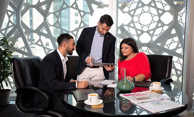 Servcorp team assists clients in a meeting room with skyline views at Doha Tower, West Bay, Doha.