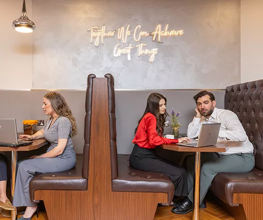Clients working in a 5-star coworking space with hot desks, collaboration booths, and spacious corridors.